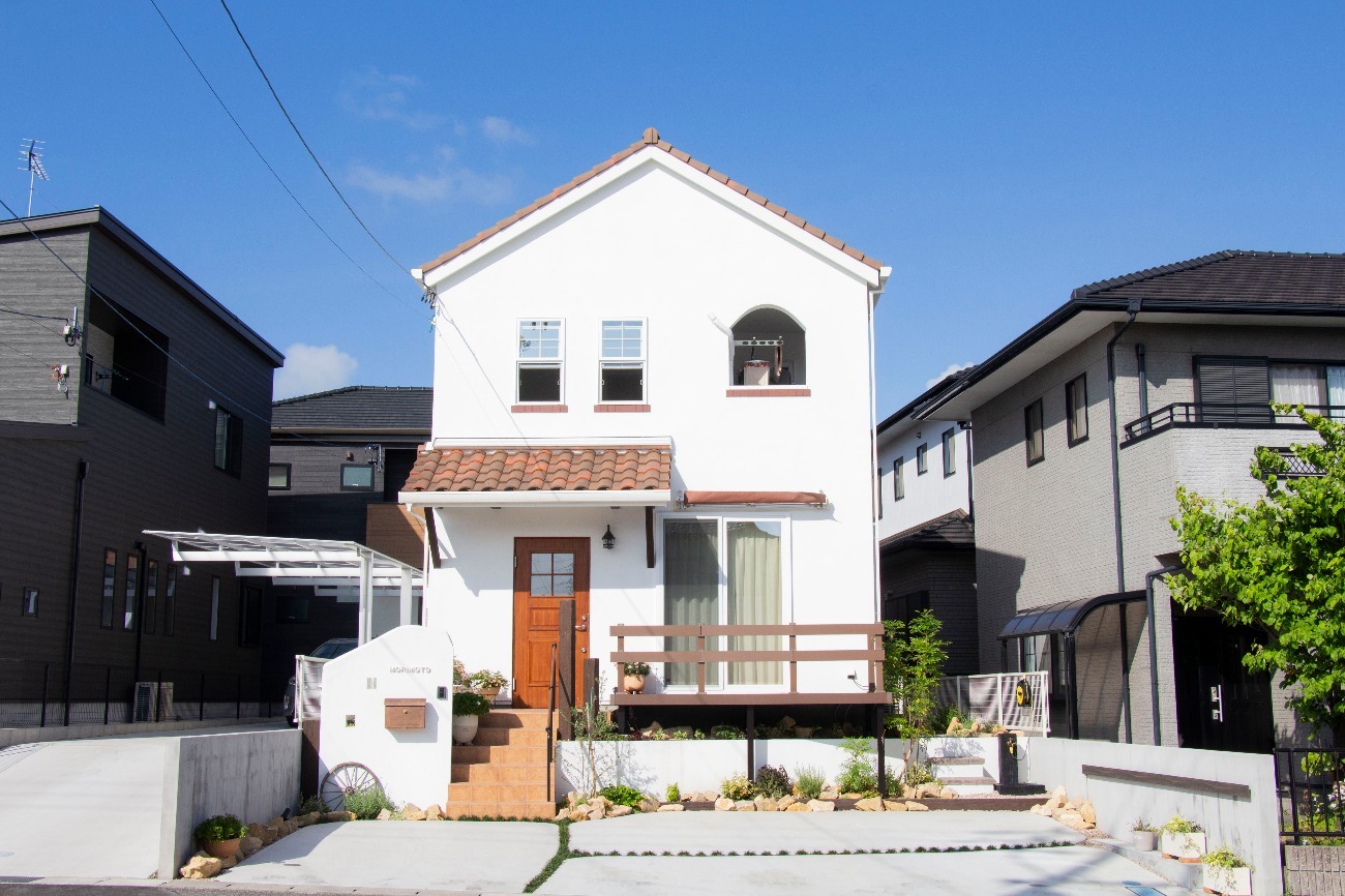 オレンジ屋根と白壁の三角屋根の住宅